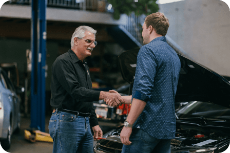 Repair shop with mechanic and customer shaking hands