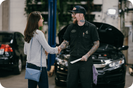 Repair shop with mechanic and customer shaking hands